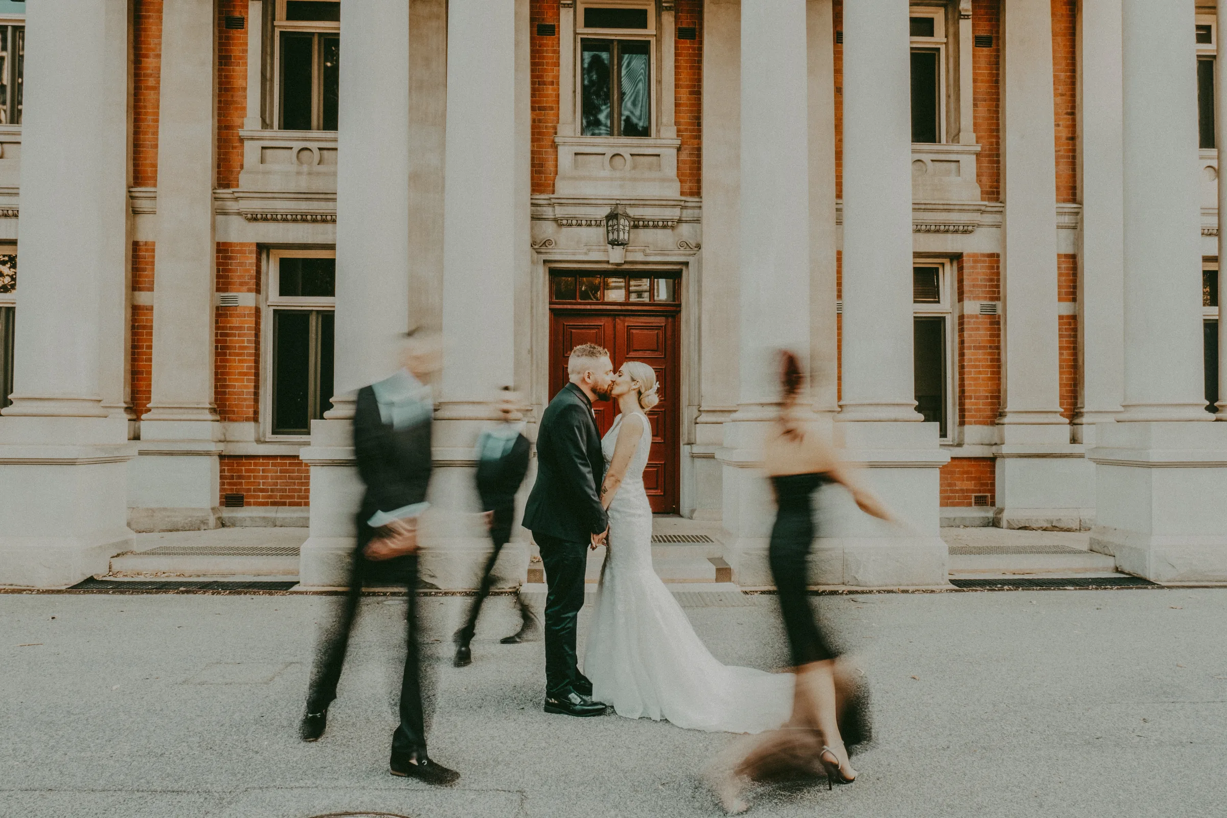 Chantelle and Zach sitting together and kissing on heritage stone steps, Perth CBD wedding photography