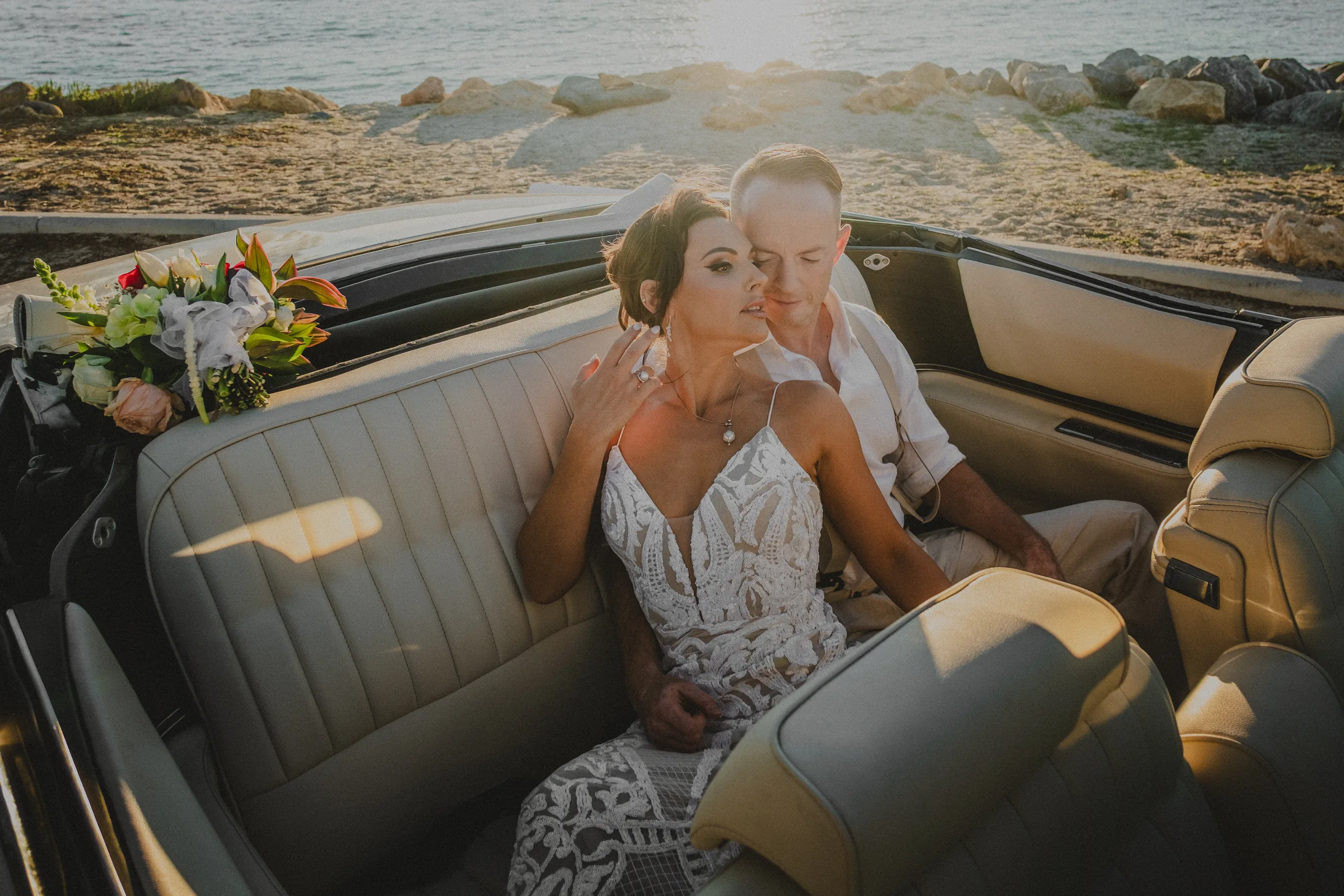 Sean embracing Katia in the back seat of a classic car at golden hour, North Fremantle wedding photography