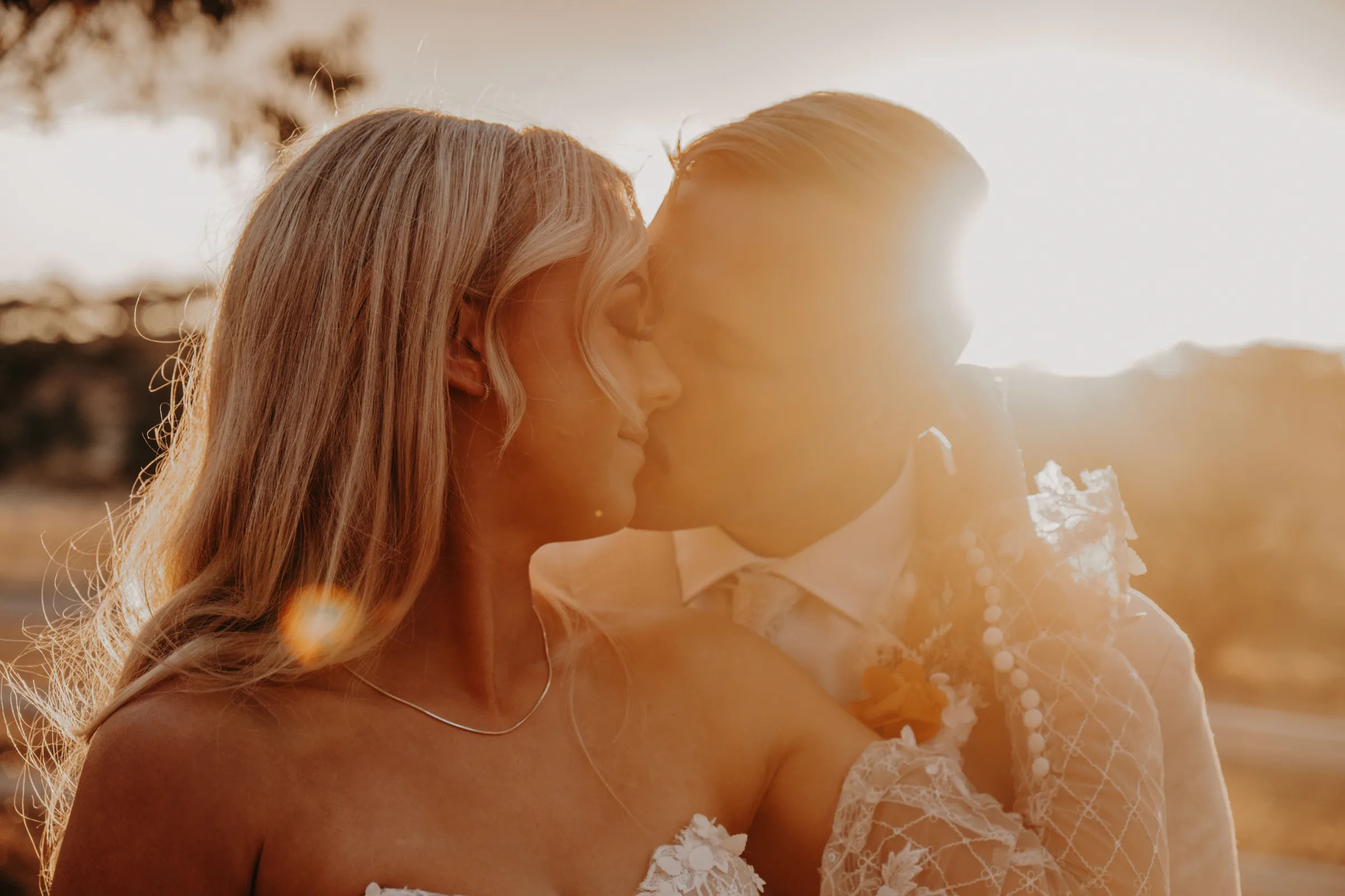 Grace and Lachie kissing in golden hour light at Buckland Estate