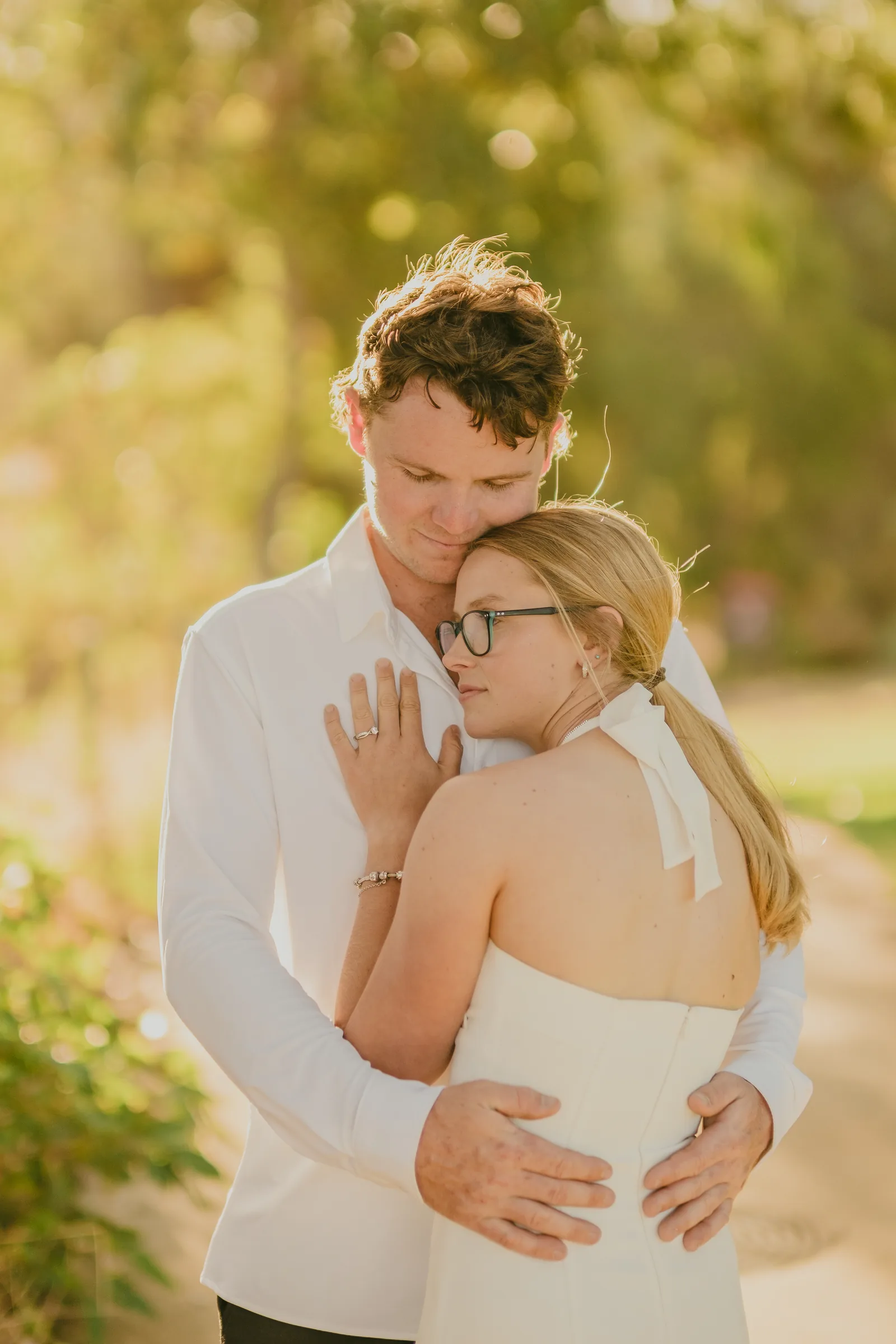 Close portrait of Kayla and Brett embracing in golden hour light at Kings Park