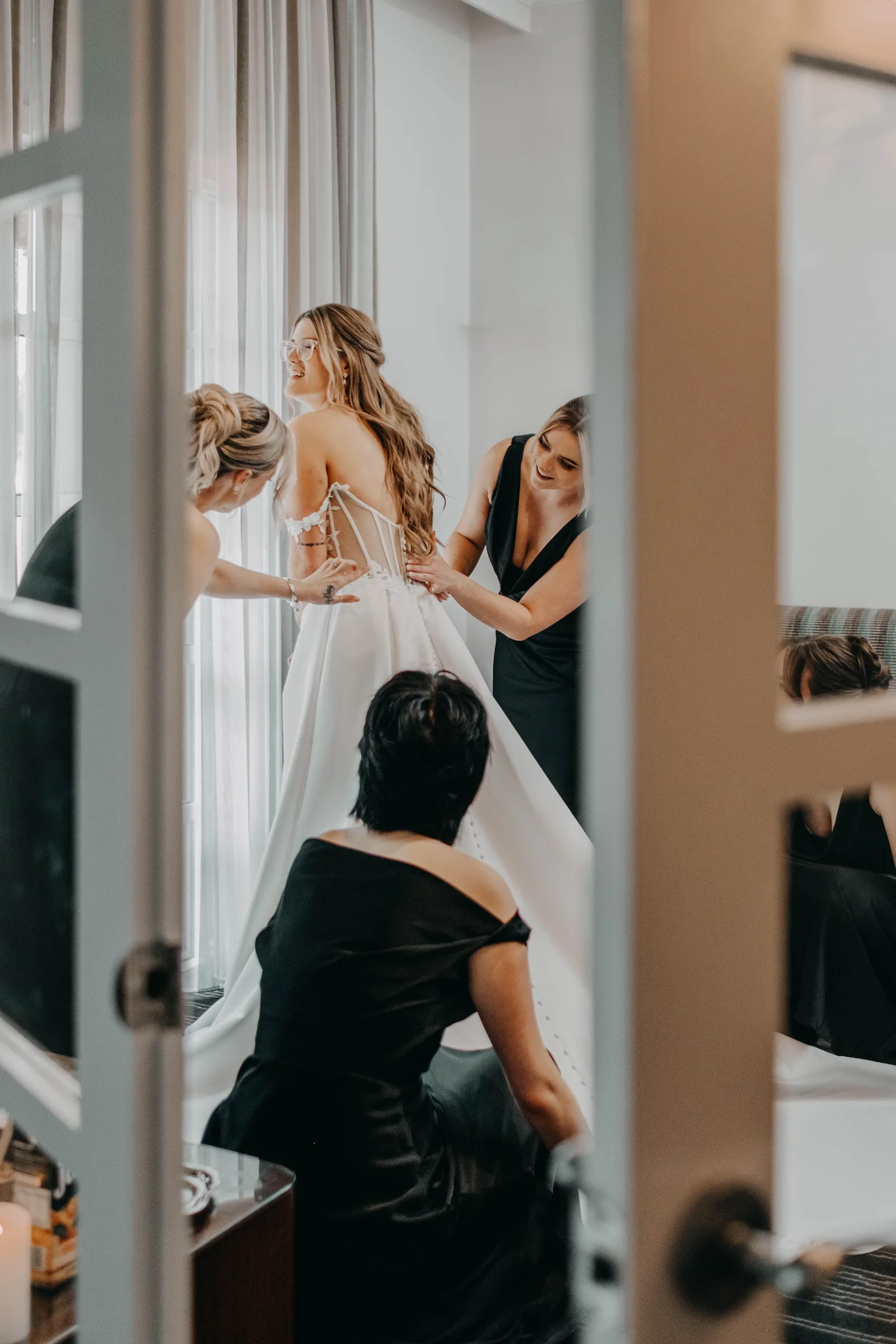 Kirra having her hair styled in front of the mirror before her wedding at The Vines Resort