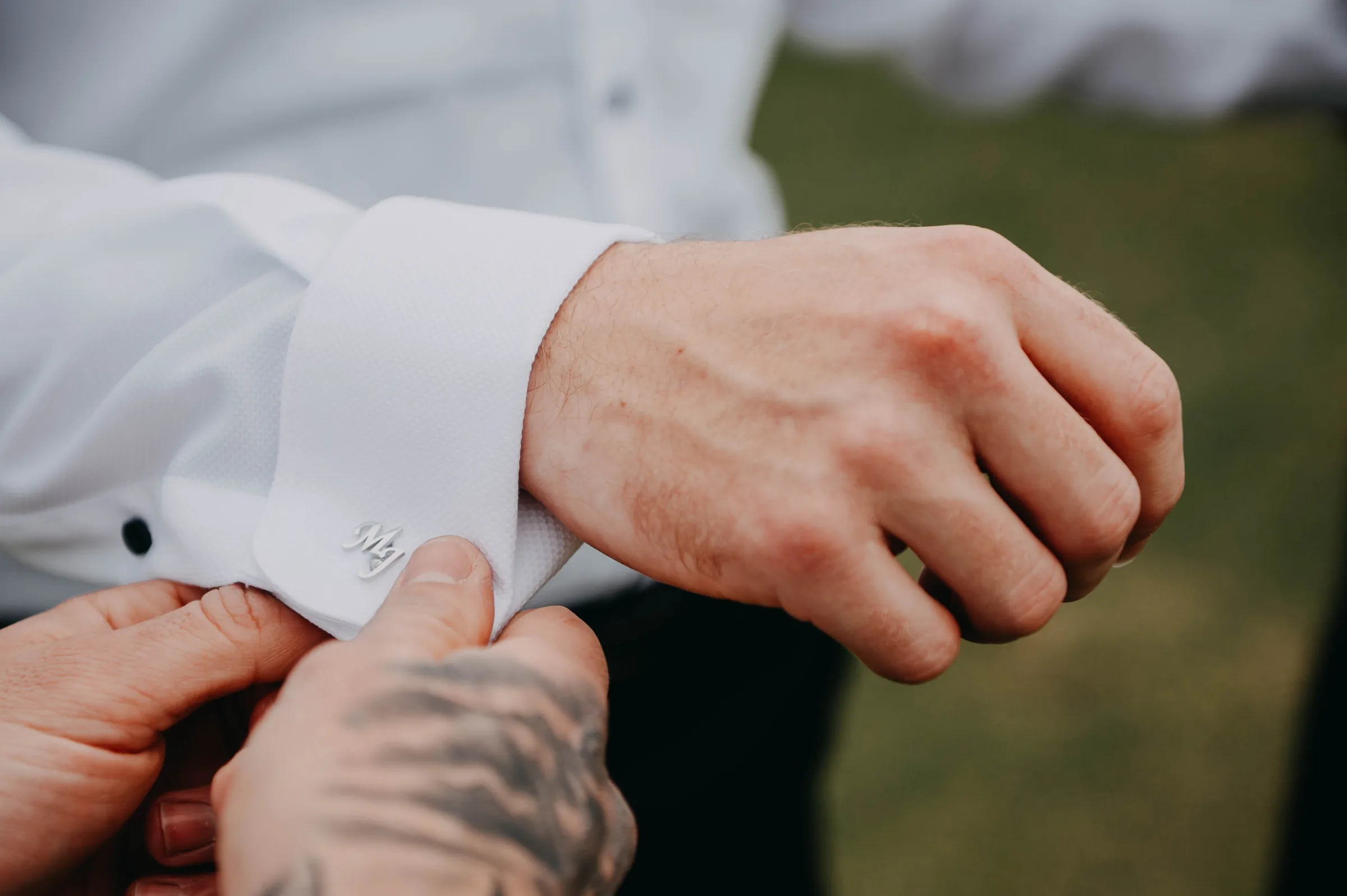 Close detail of Mitch fastening his cufflink before his wedding at The Vines Resort