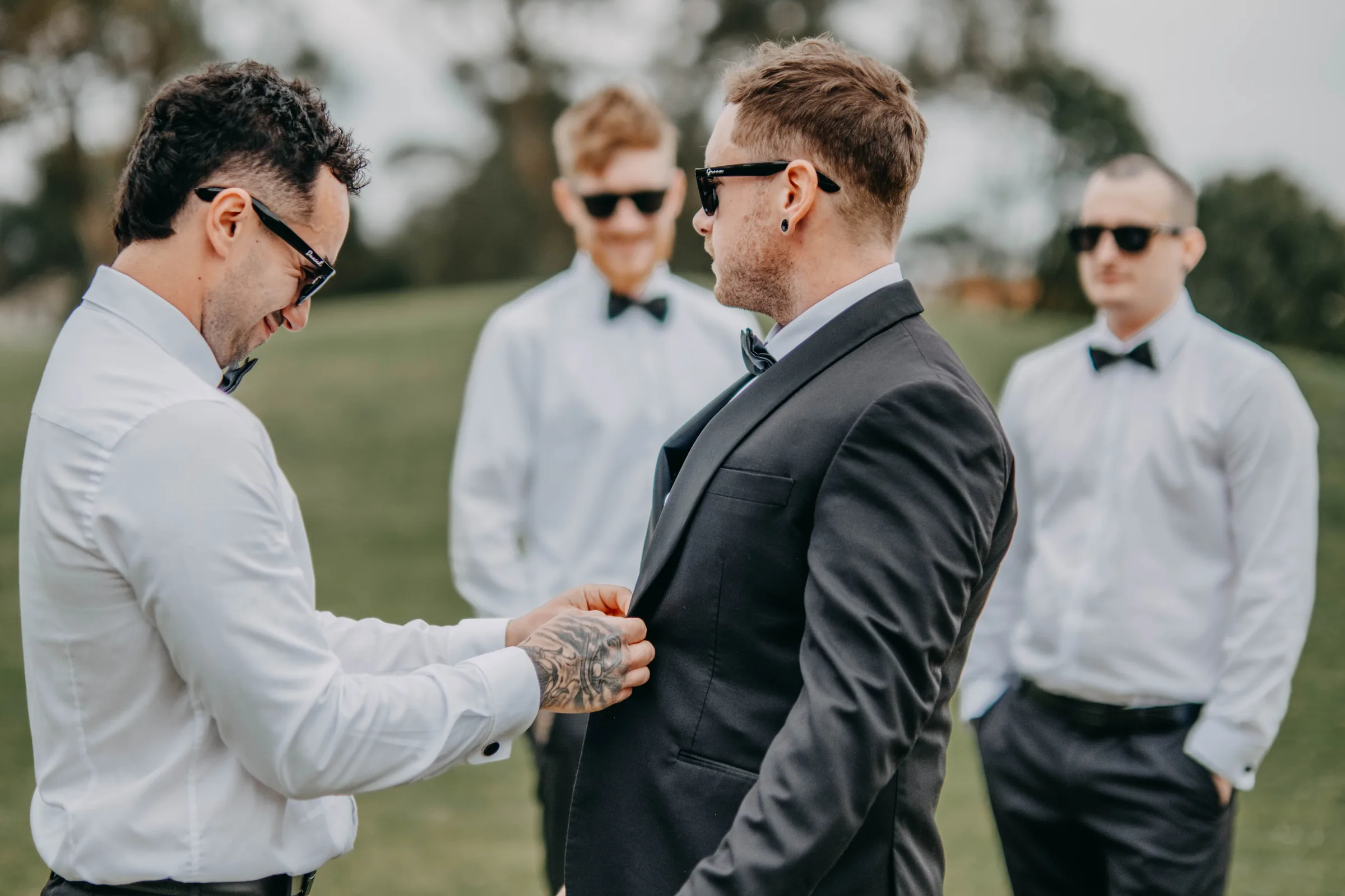 Mitch and his groomsmen in sunglasses walking together across The Vines Resort lawn