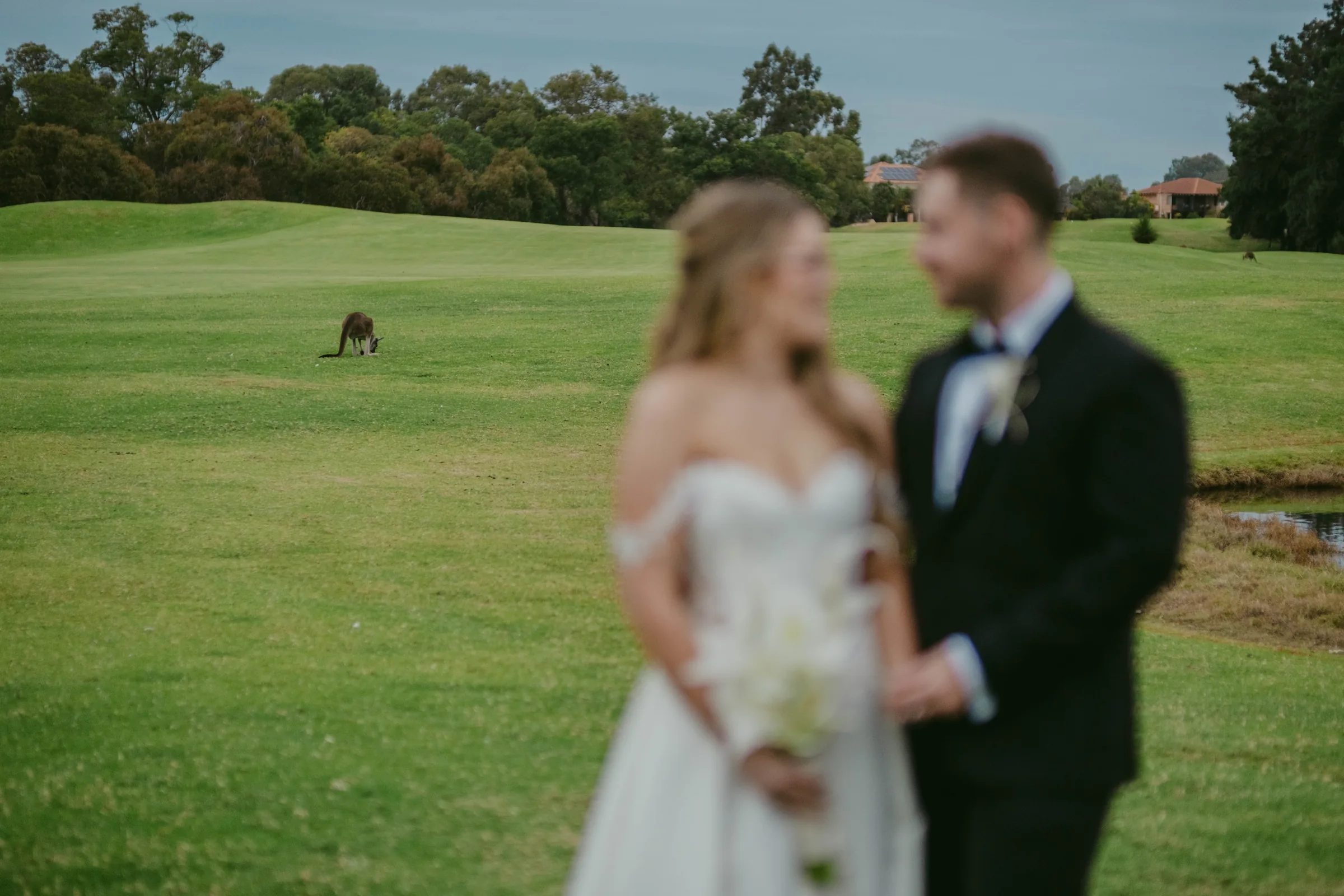 Kirra and Mitch standing back to back on The Vines Resort fairway during portraits