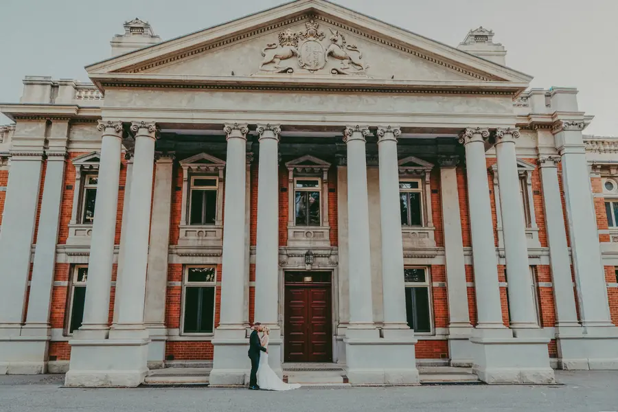 Bride and groom kissing in front of the heritage Supreme Court Gardens building, Perth CBD