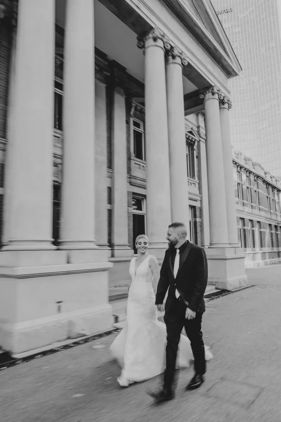 Chantelle and Zach embracing in front of the heritage Supreme Court Gardens building, Perth