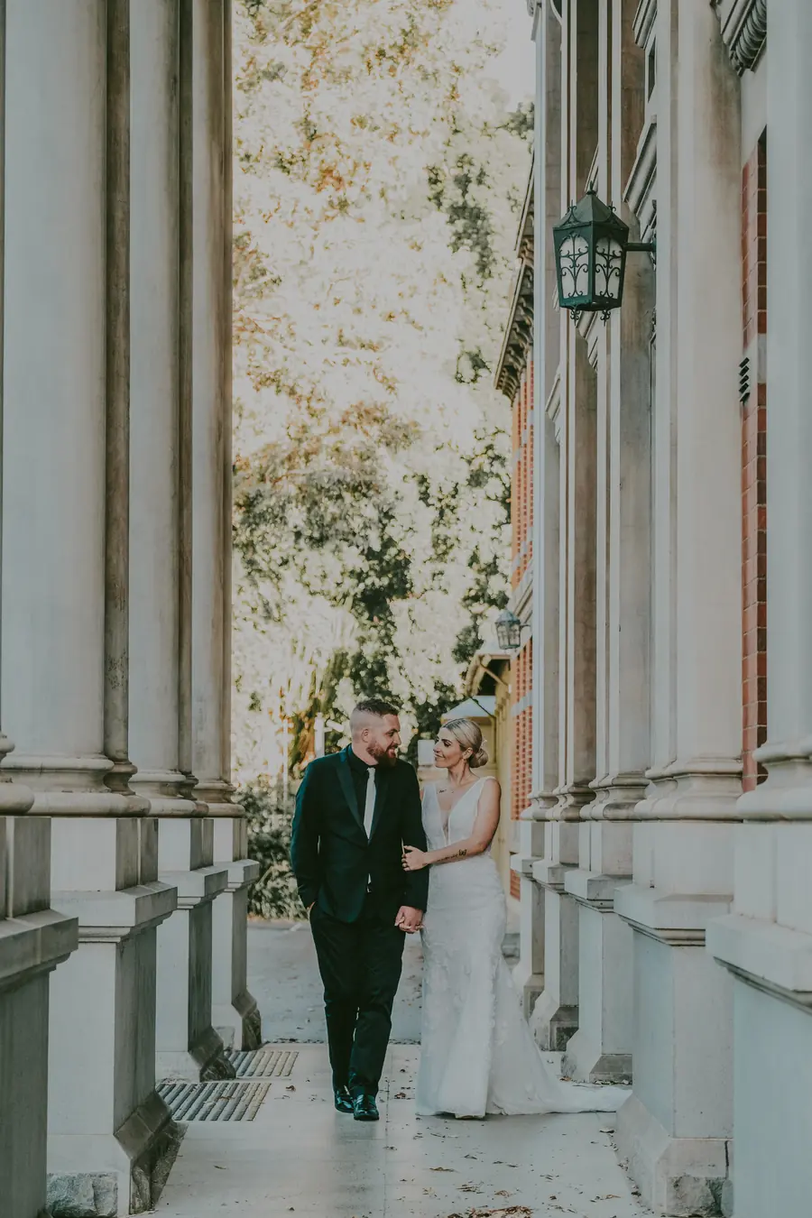 Chantelle and Zach sitting together and kissing on heritage stone steps, Perth CBD wedding photography