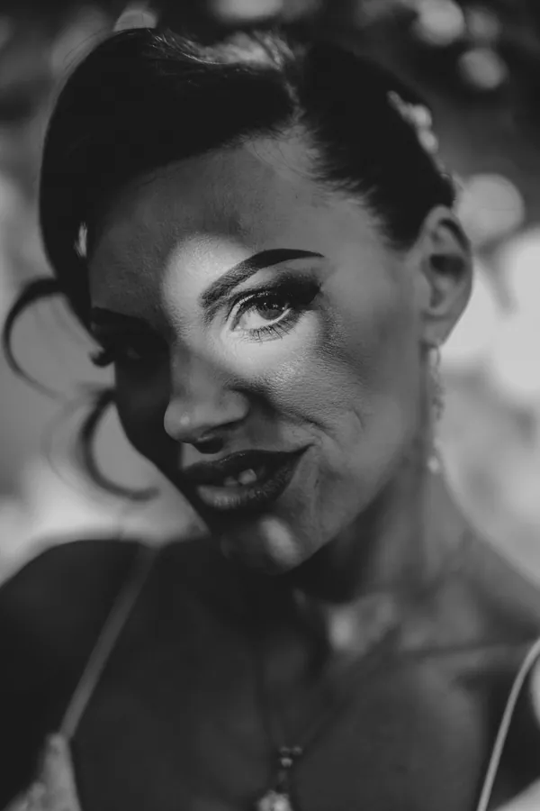 Black and white close-up portrait of Katia smiling softly before the ceremony