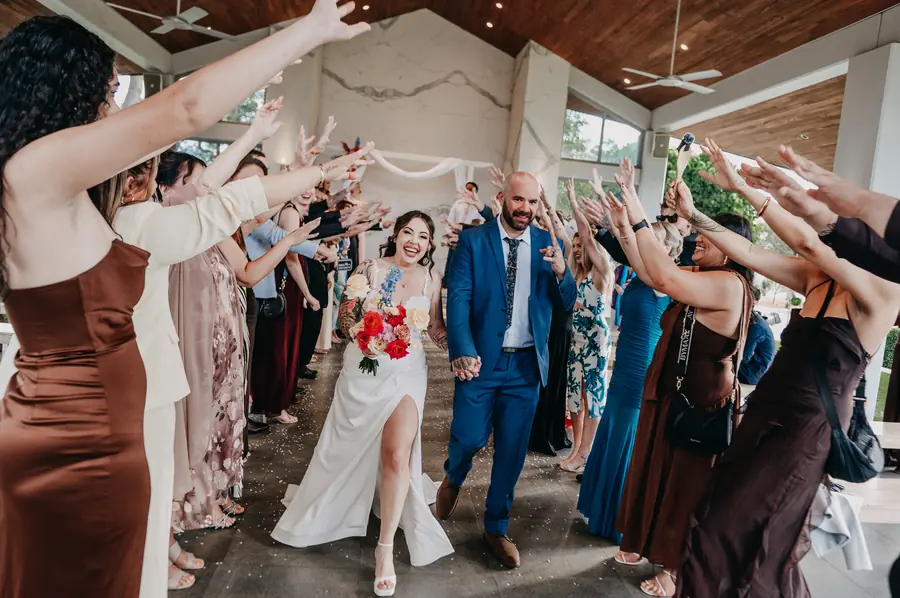 Kerry and Richard's wedding ceremony exit under a canopy of raised hands at The Vines Resort, Perth