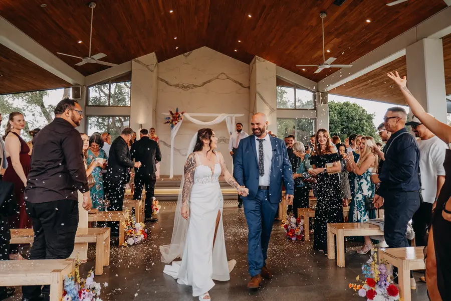 Guests cheering as Kerry and Richard walk back down the aisle at their Vines Resort wedding ceremony