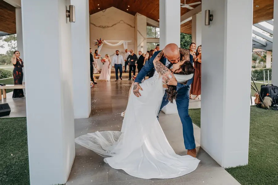 Groom cutting the wedding cake and cupcake tower as the bride laughs, Perth wedding photography