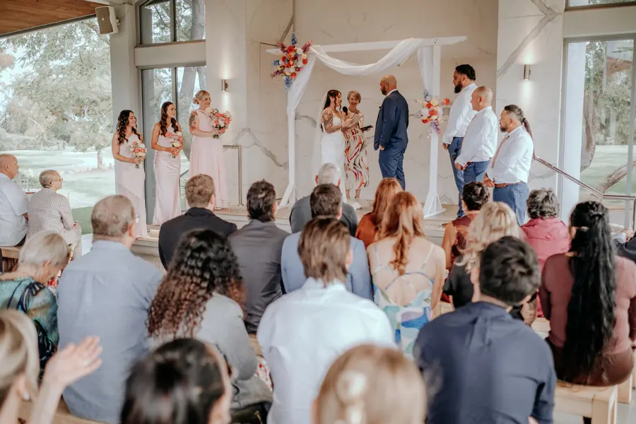 Wide view of the wedding ceremony at The Vines Resort with guests seated under the pavilion
