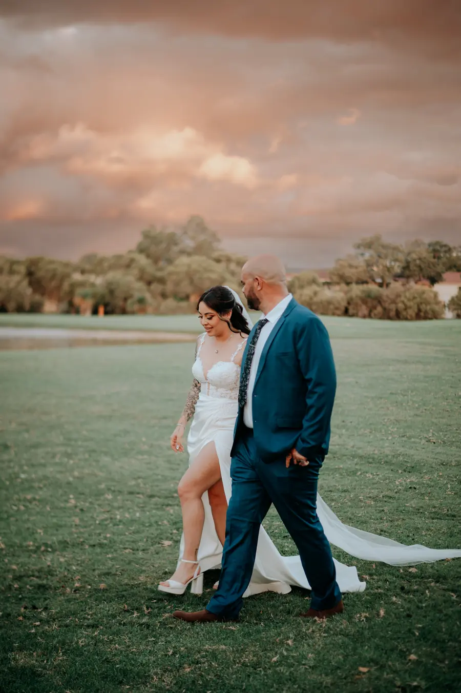 Bride and groom walking hand in hand at golden hour, The Vines Resort wedding