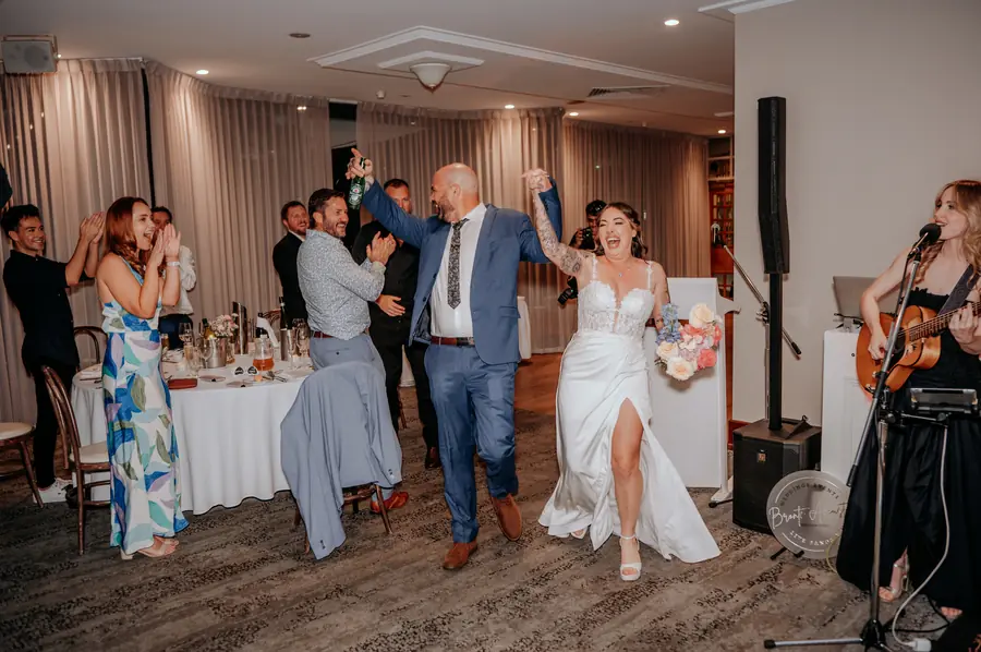 Newlyweds dancing arm in arm as a live band plays at their Vines Resort wedding reception