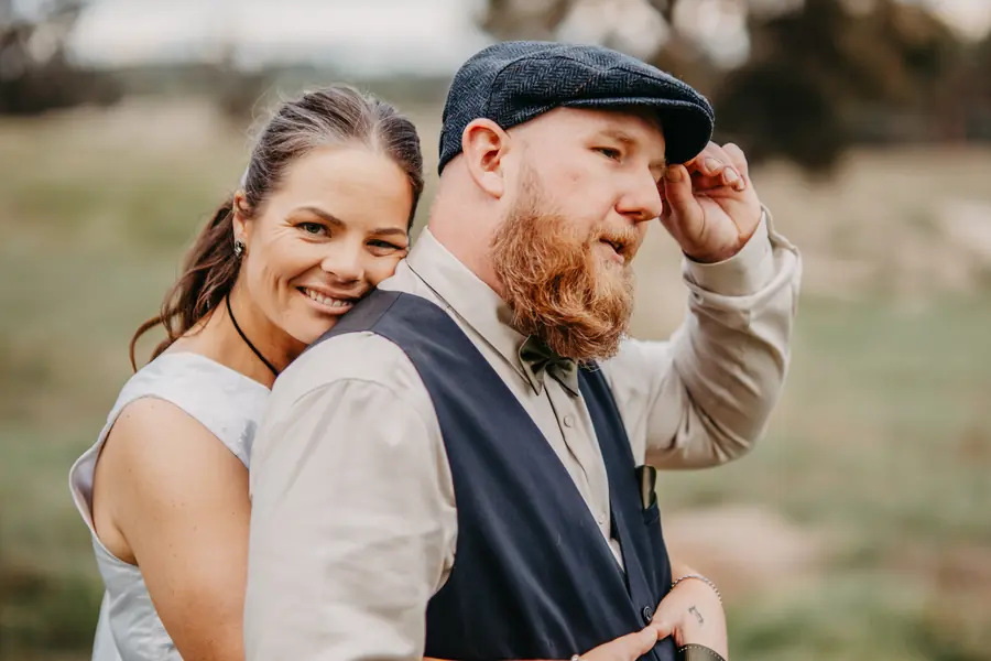 Bride and groom laughing together beside a rusted vintage farm truck at Dalmore Farm, WA wheatbelt wedding