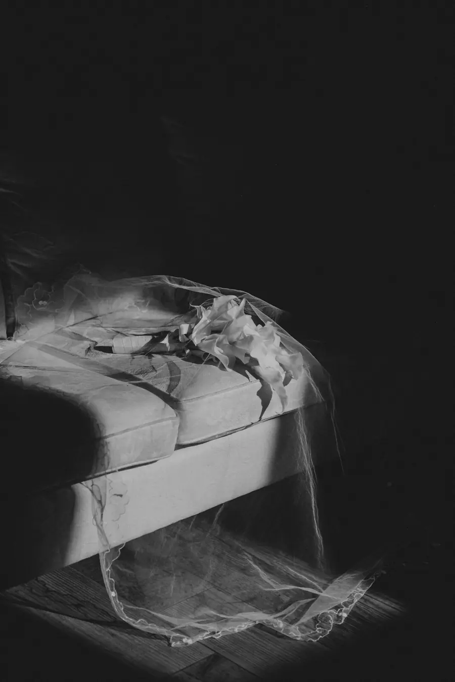 Black and white detail of Liv's veil draped over a chair before her Dalmore Farm wedding