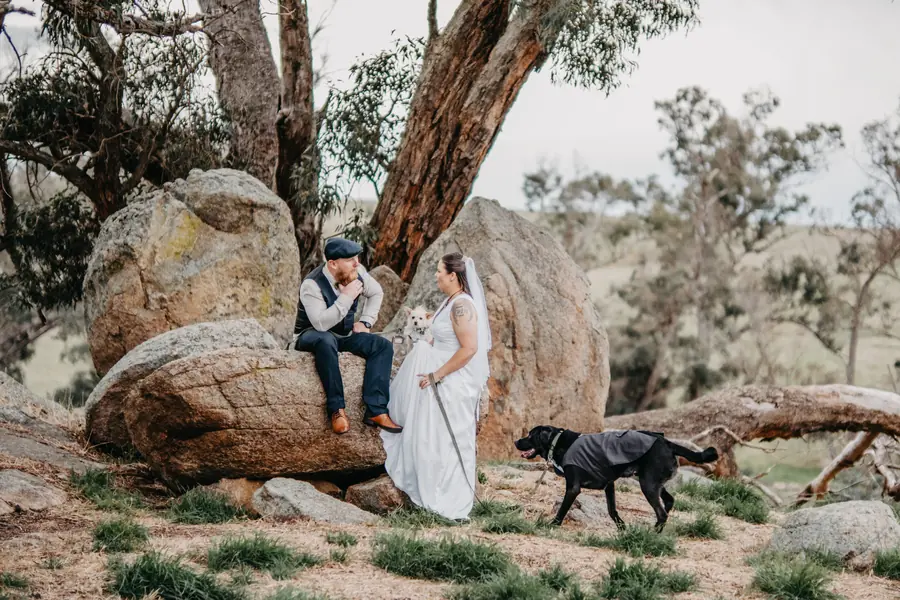 Liv and Ben with their dogs among granite boulders and gum trees at Dalmore Farm
