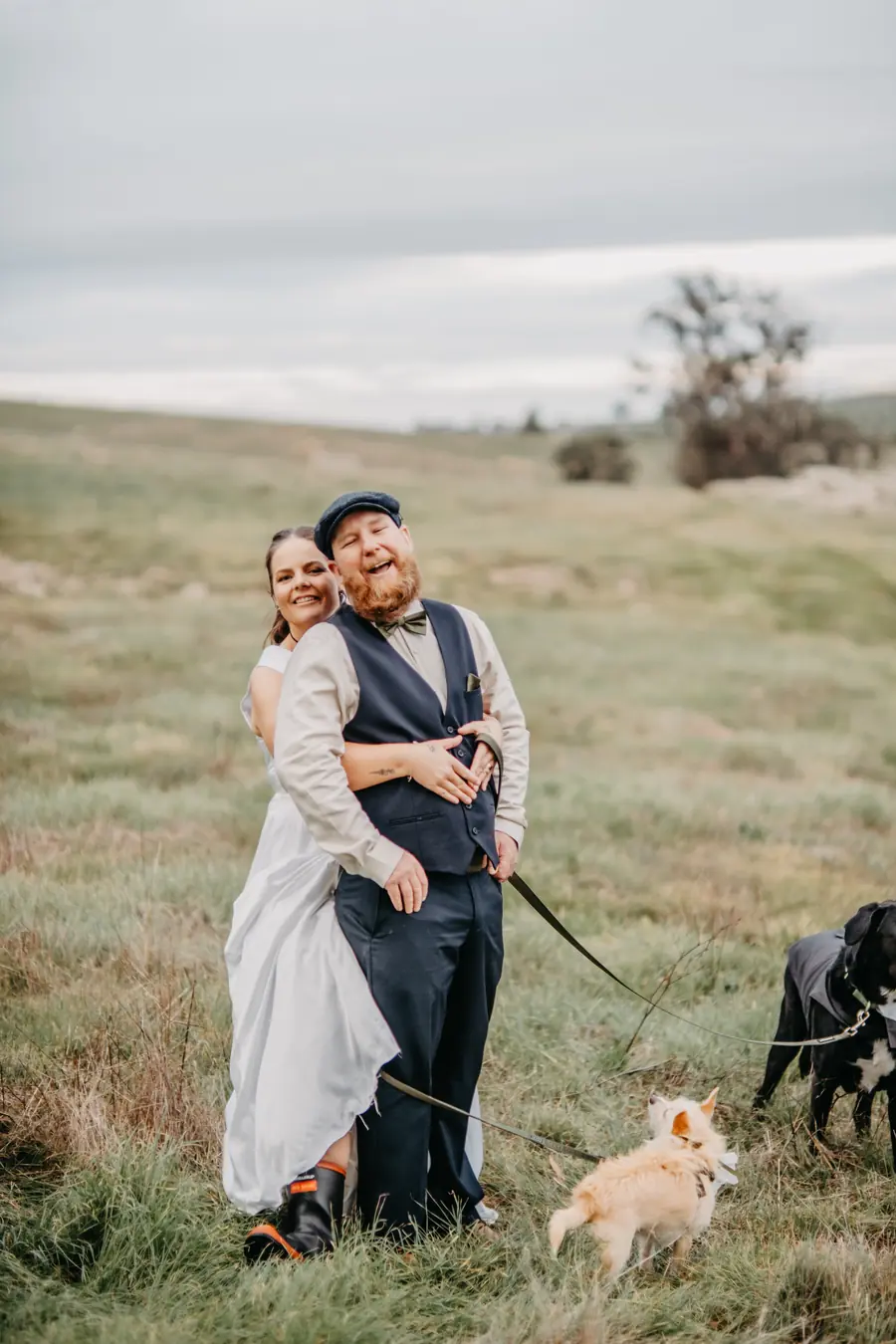 Liv and Ben laughing together in the paddock with their dogs at Dalmore Farm
