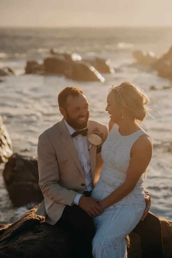 Victoria and Luck laughing together in the golden hour light on the rocks