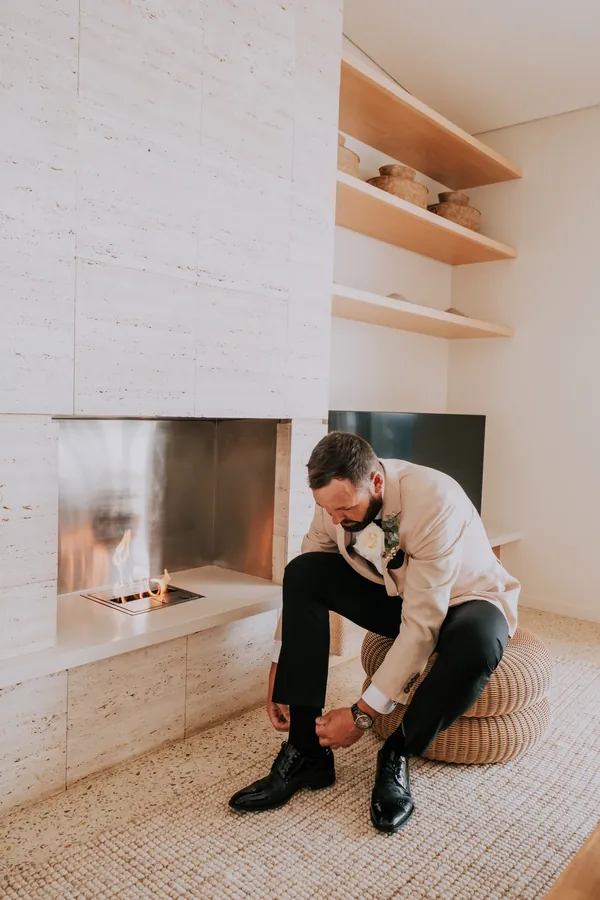 Luck tying his shoes by the fireplace while getting ready at Injidup Spa Retreat