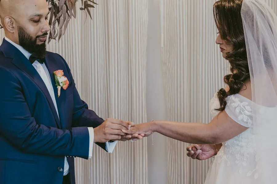 Close-up of Jibin placing the ring on Betsy's finger during the ceremony
