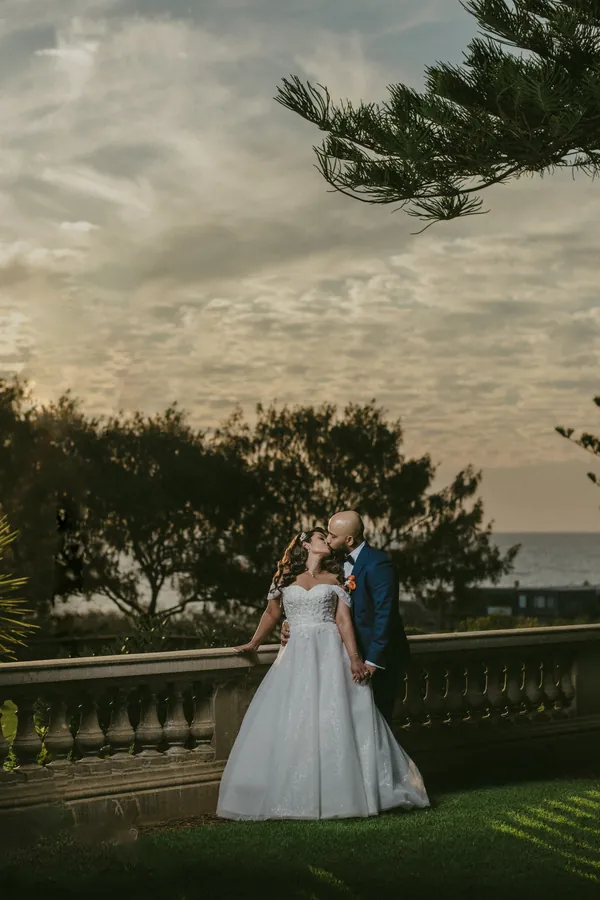 Jibin dipping Betsy for a kiss on the lawn at Cottesloe Civic Centre at golden hour