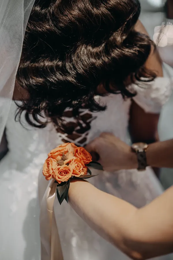 Close-up of Betsy's curled hair and orange rose corsage while getting ready