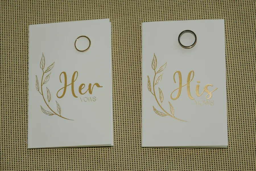 Two ring boxes marked 'Her' and 'His' laid out before the ceremony