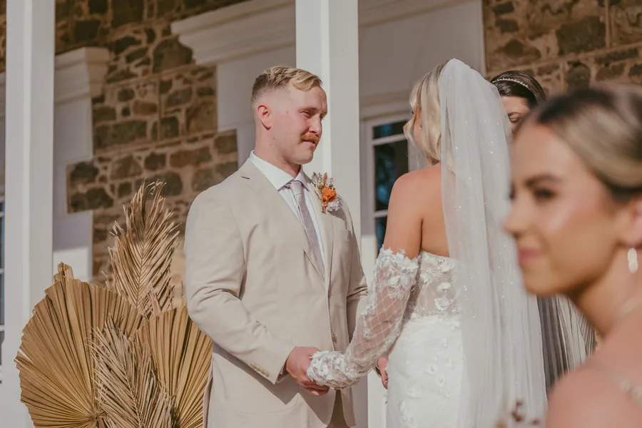 Lachie looking emotional at Grace during their vows at Buckland Estate, dried florals in the foreground