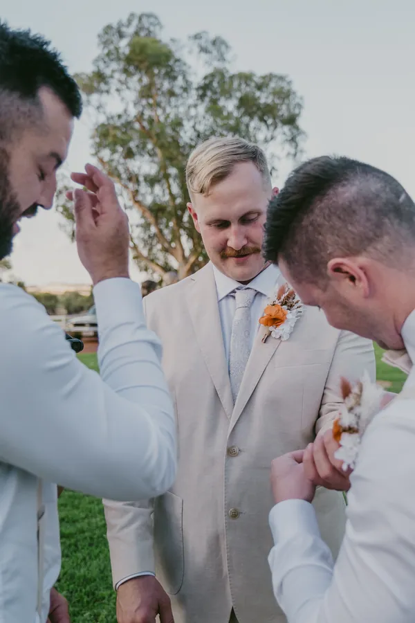 Groomsman pinning a boutonniere before Grace and Lachie's ceremony at Buckland Estate