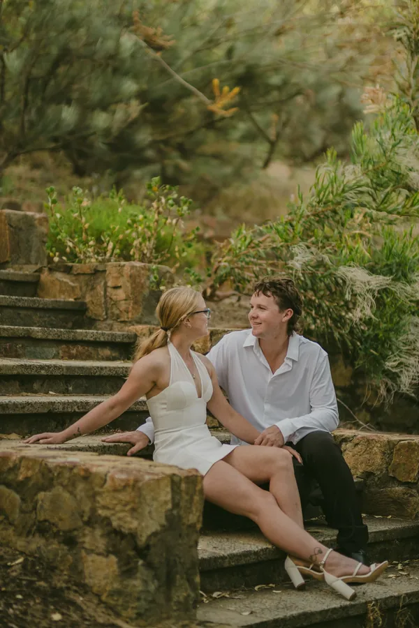 Kayla and Brett sitting together on an old stone stairway in Kings Park
